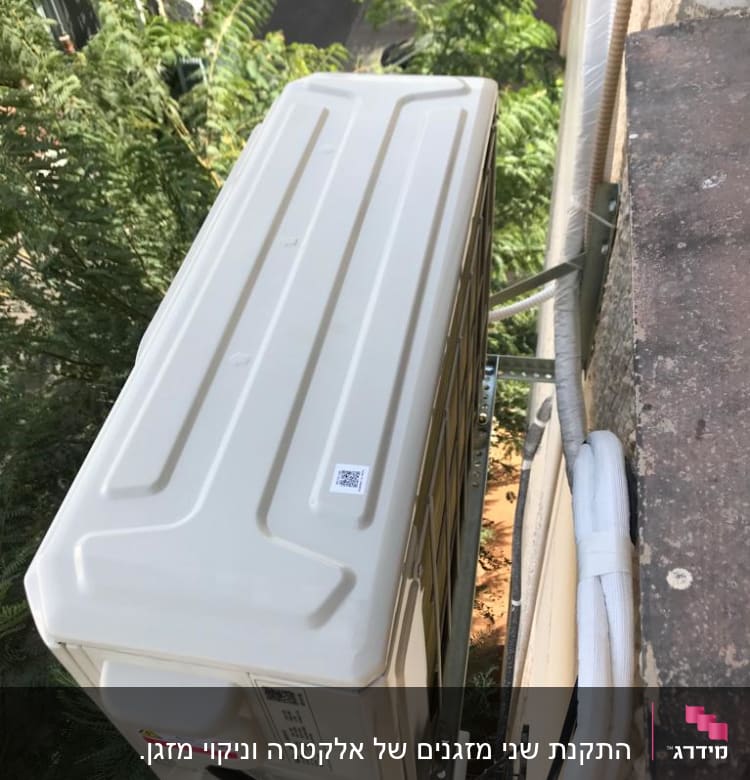יחידת מזגן חיצונית מותקנת על קיר עם צינורות